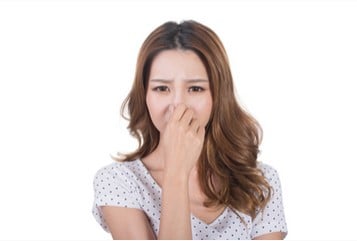 woman holding nose