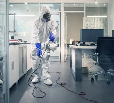 An employee sanitizing an office space