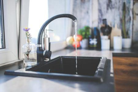 black water faucet with water falling from the faucet