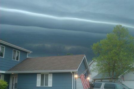 Blue house with dark skies behind the home