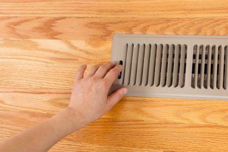 Hand on an air vent in the floor