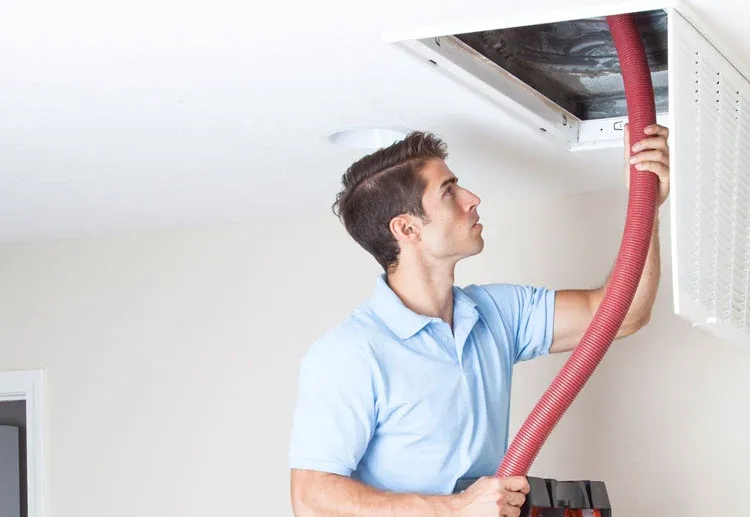A man cleaning air ducts