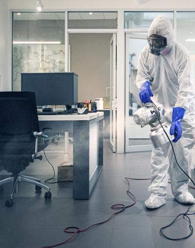An employee sanitizing an office space