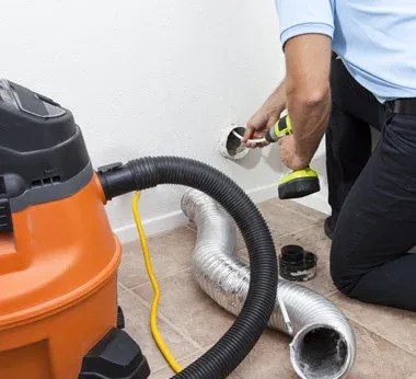 A man cleaning a dryer vent
