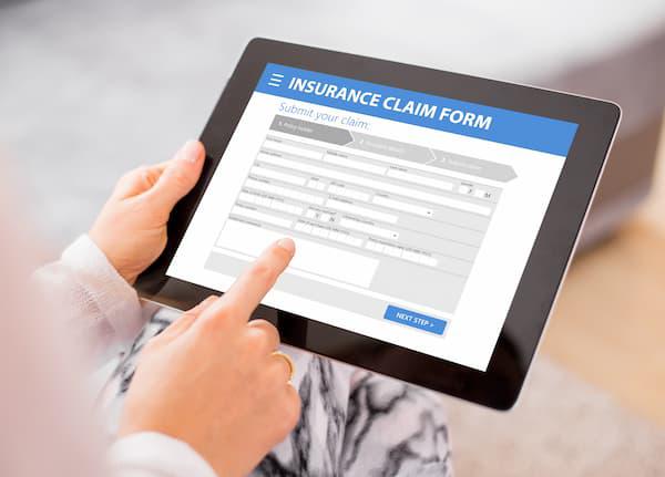 A person using a tablet to file an insurance claim