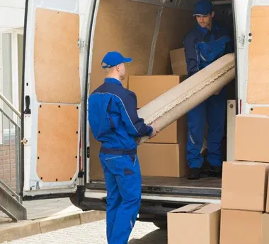 Two employees moving boxes from a van