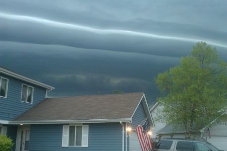 Blue house with dark skies behind the home